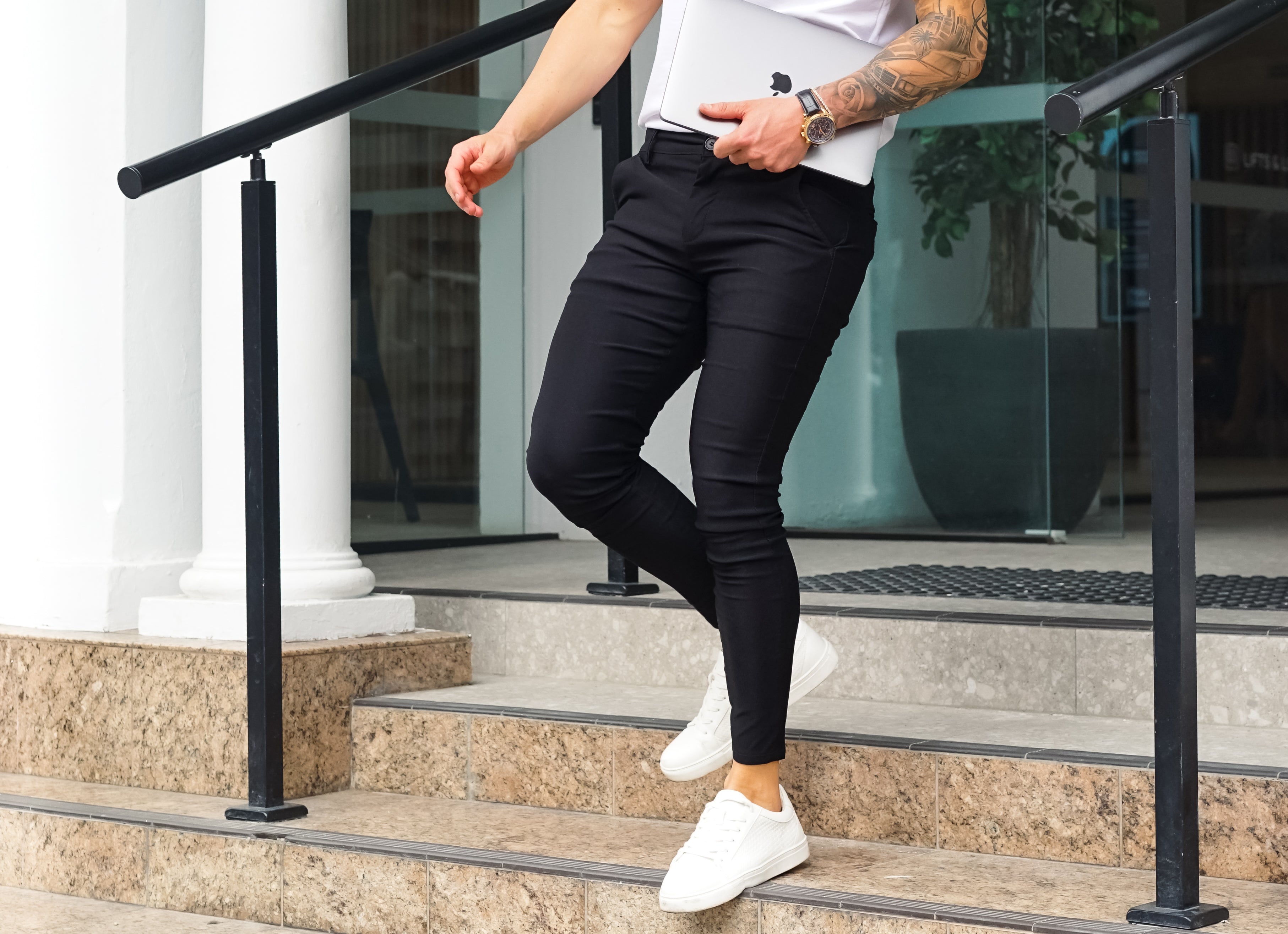 Walking down the stairs in white t-shirt and black chino pants
