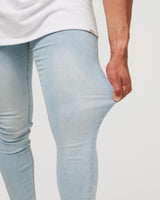 Stretching mens light blue jeans